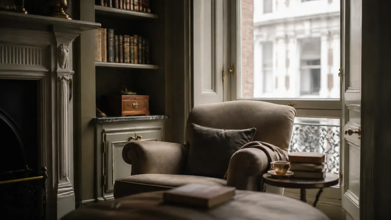 Calm reading space inside a quiet London period home with soft light by an acoustically glazed window