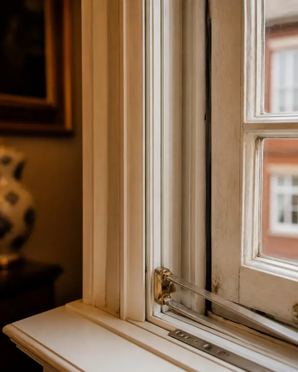 Detail shot showing clearance around a window stay between the original timber casement and the internal acoustic secondary glazing unit