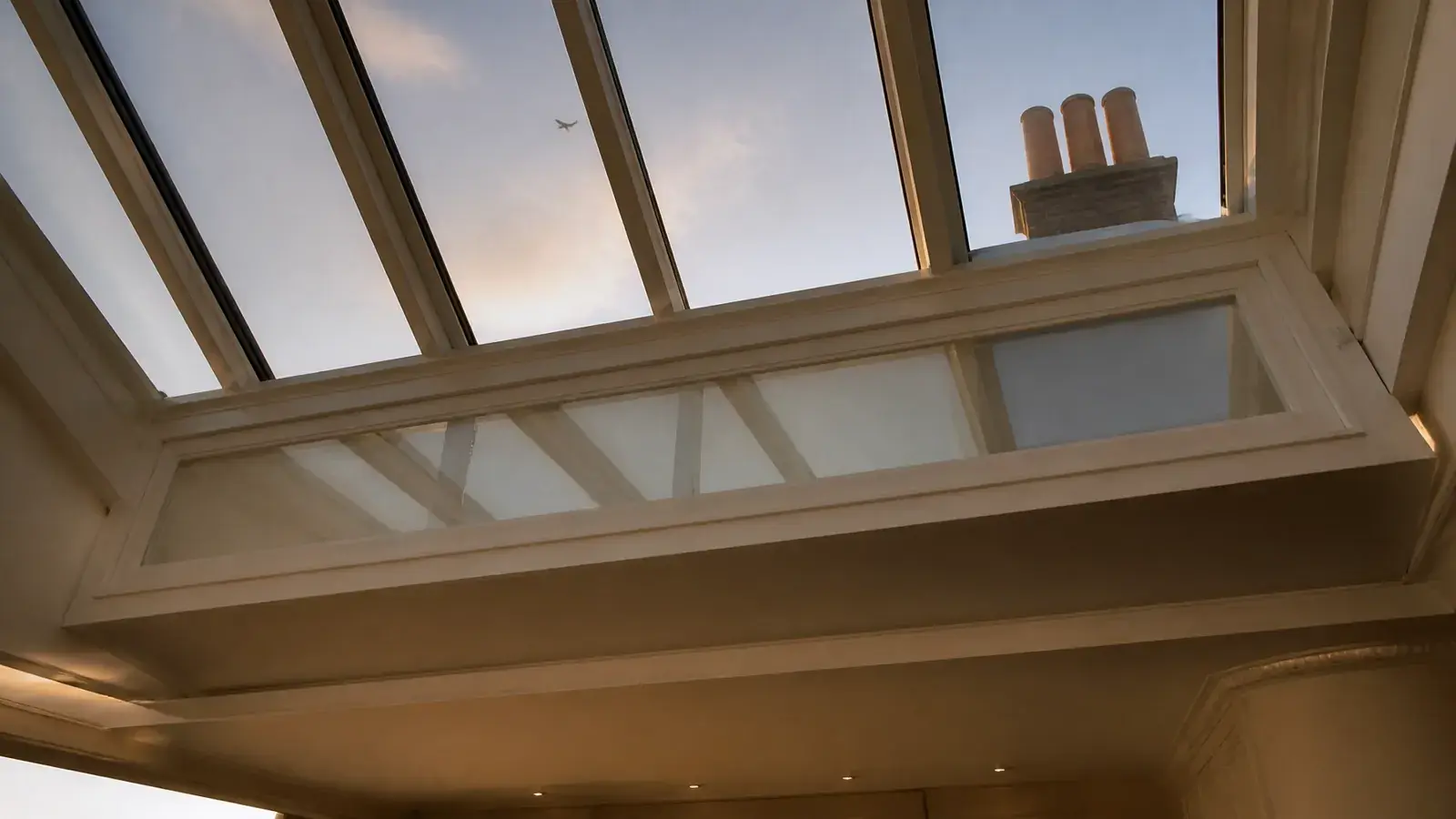 Detailed view of a secondary glazing panel fitted beneath a heritage rooflight in a top-floor room