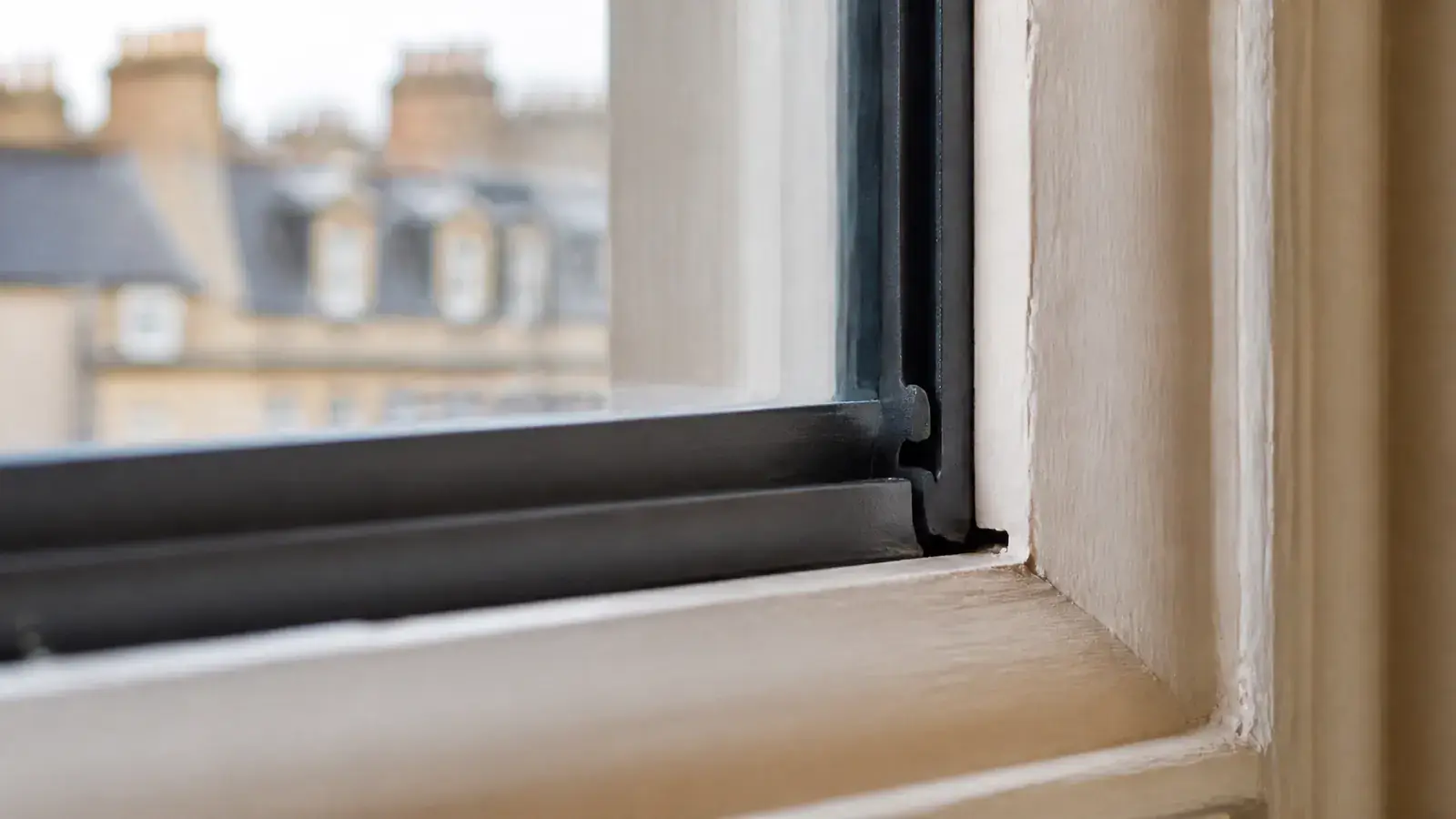Close-up detail of a twin-compression EPDM secondary glazing seal in a heritage London window, showing the precise airtight fit
