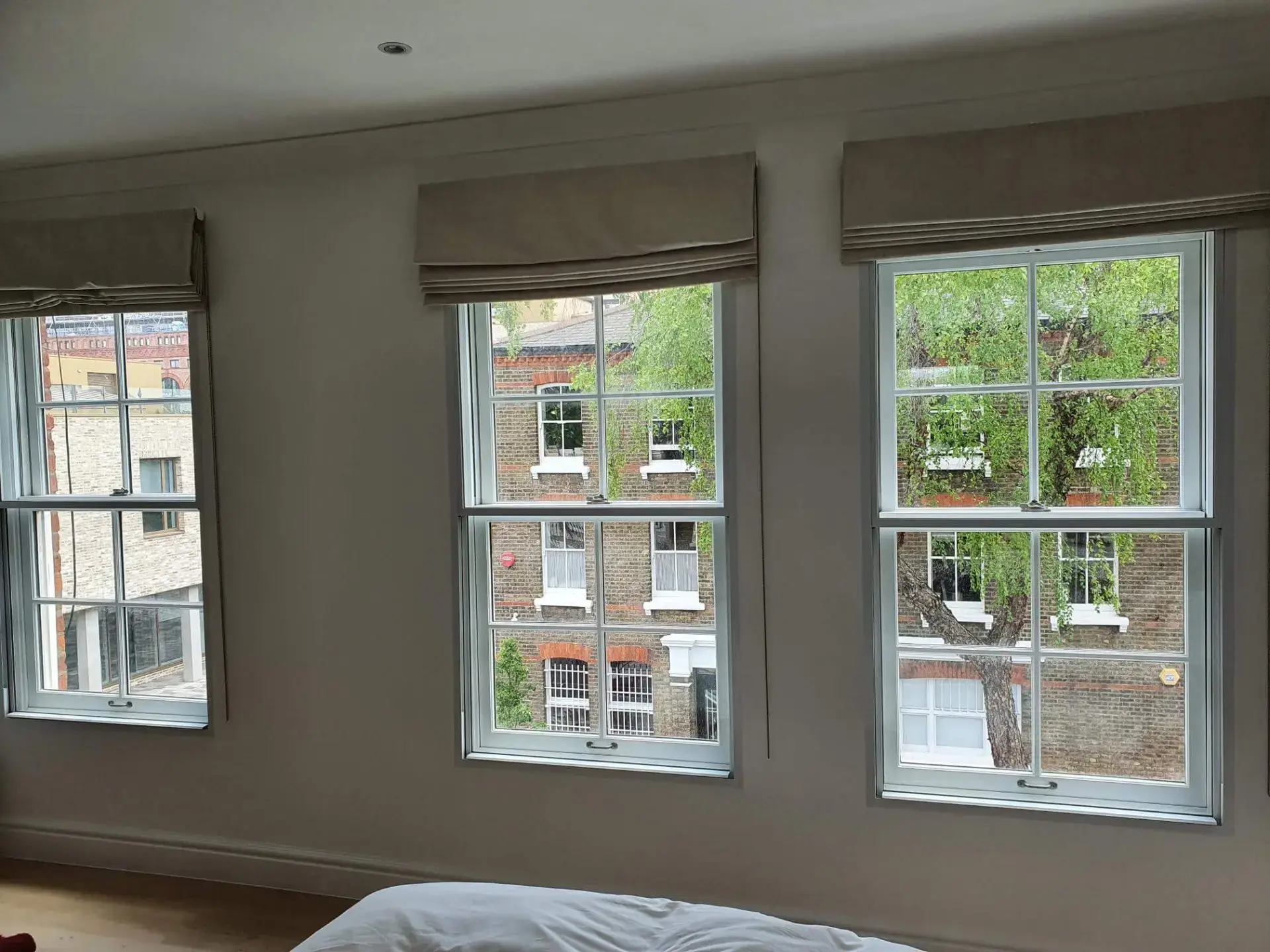 Bright daytime comparison showing a slim modern aluminium frame and a heritage timber sash secondary glazing solution side by side