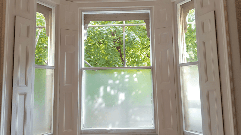Heritage-approved secondary glazing preserving period shutters in a listed London townhouse