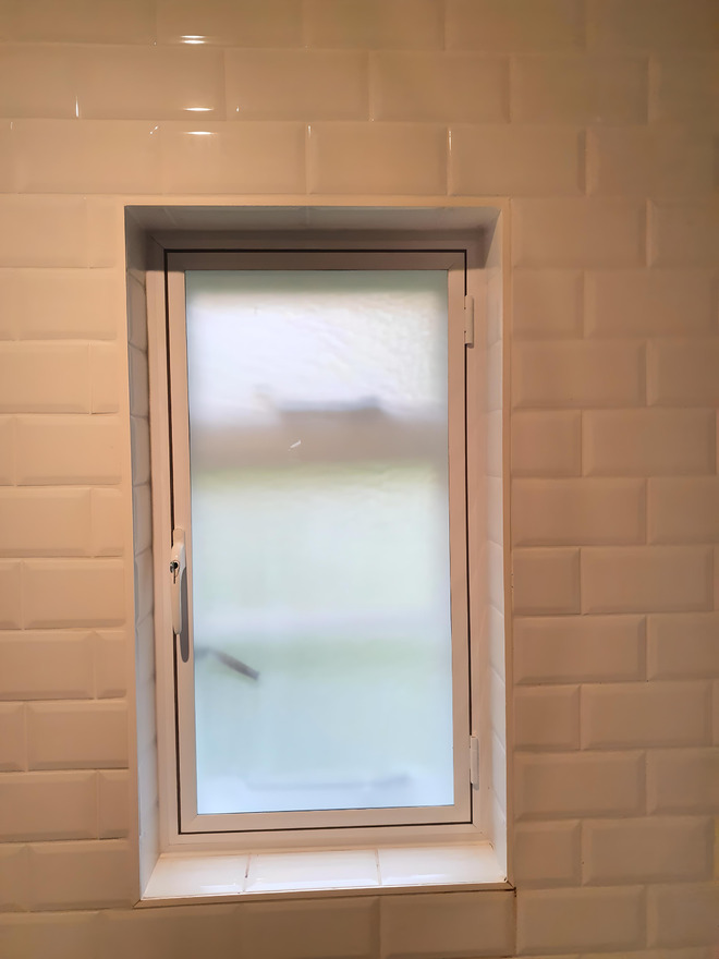 Moisture-resistant acoustic secondary glazing with privacy glass in a London bathroom